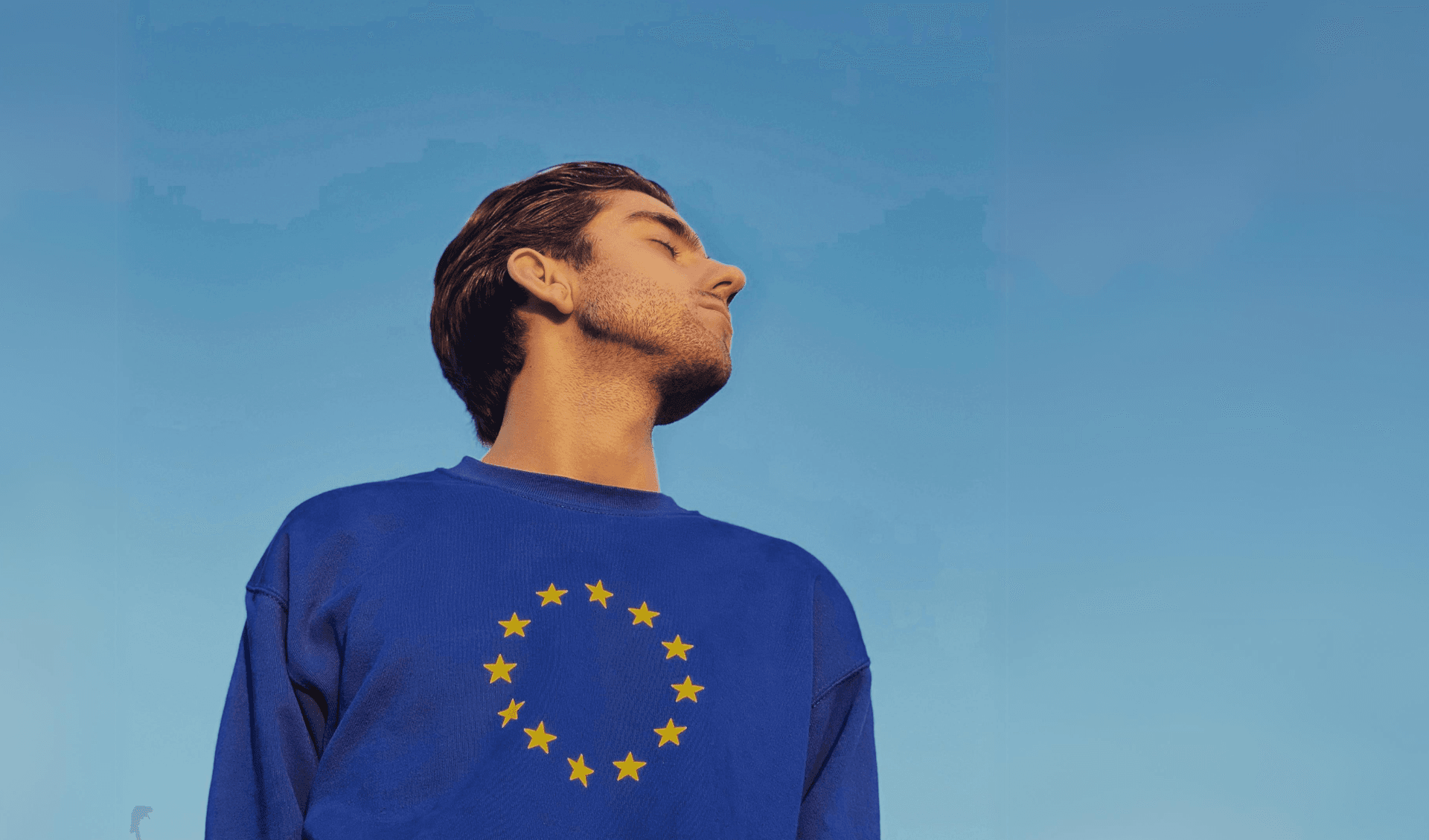Person wearing EU pullover with their head turned to the sky