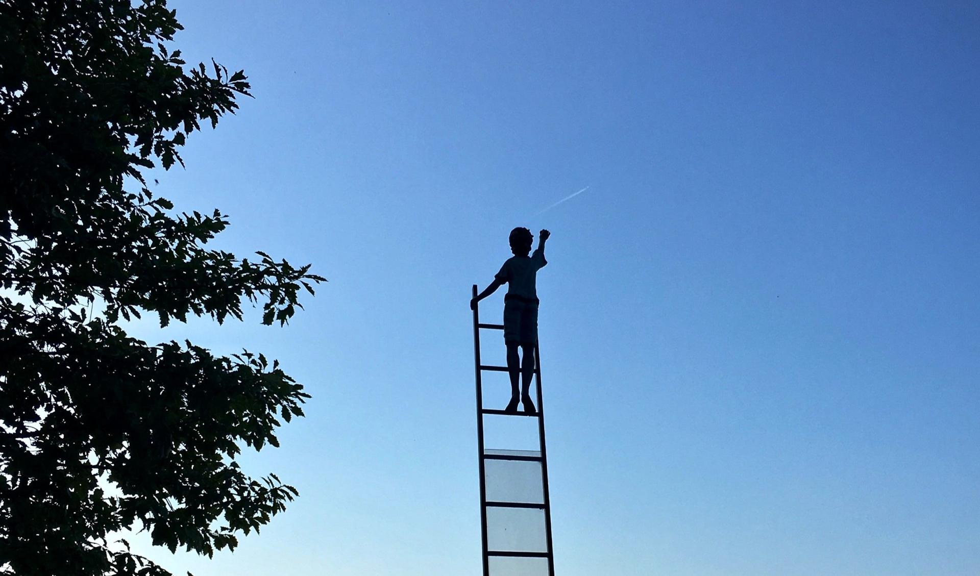 A young person is standing on a latter that directs to the blue sky