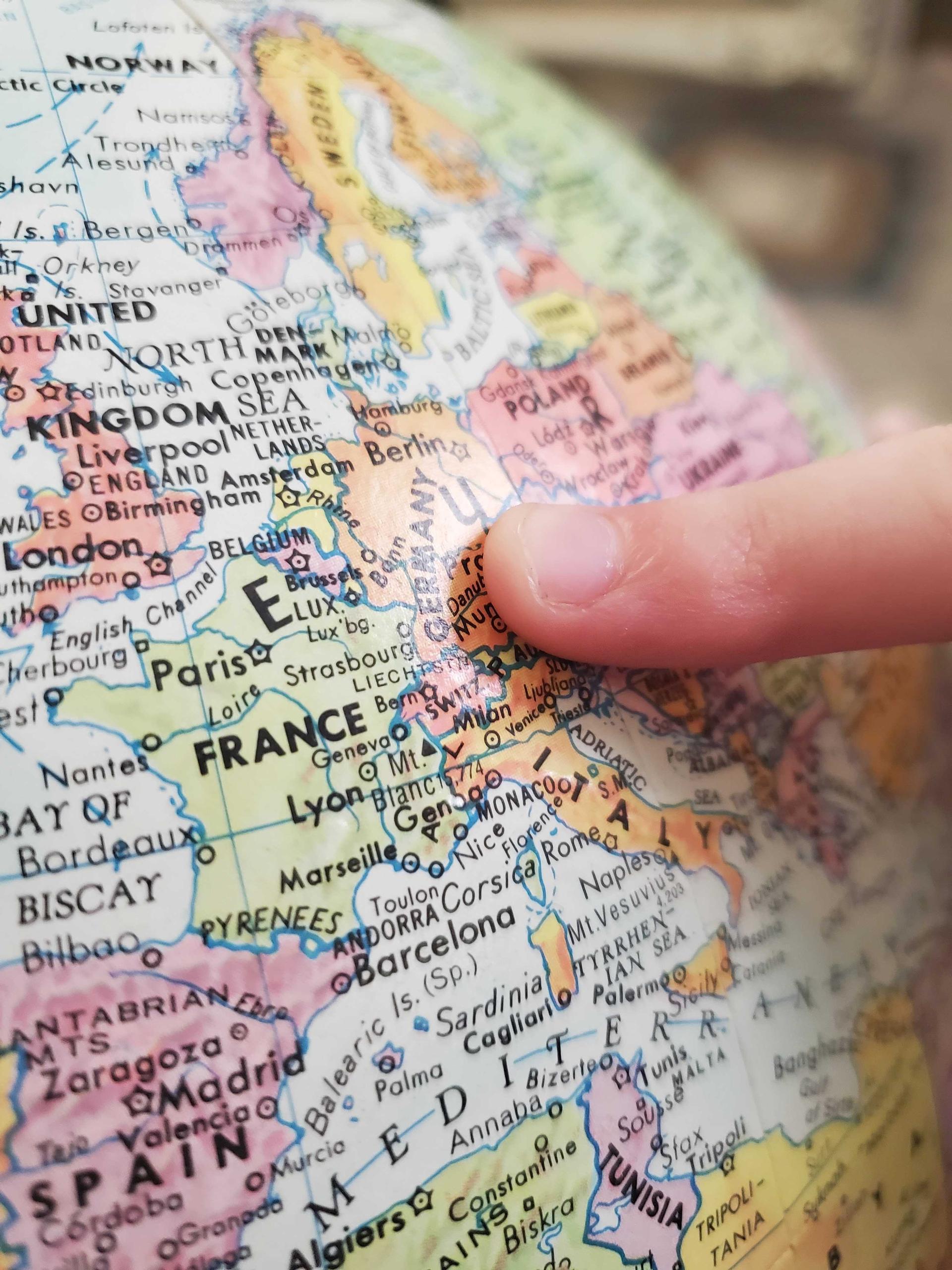 A finger is pointing on a map on germany
