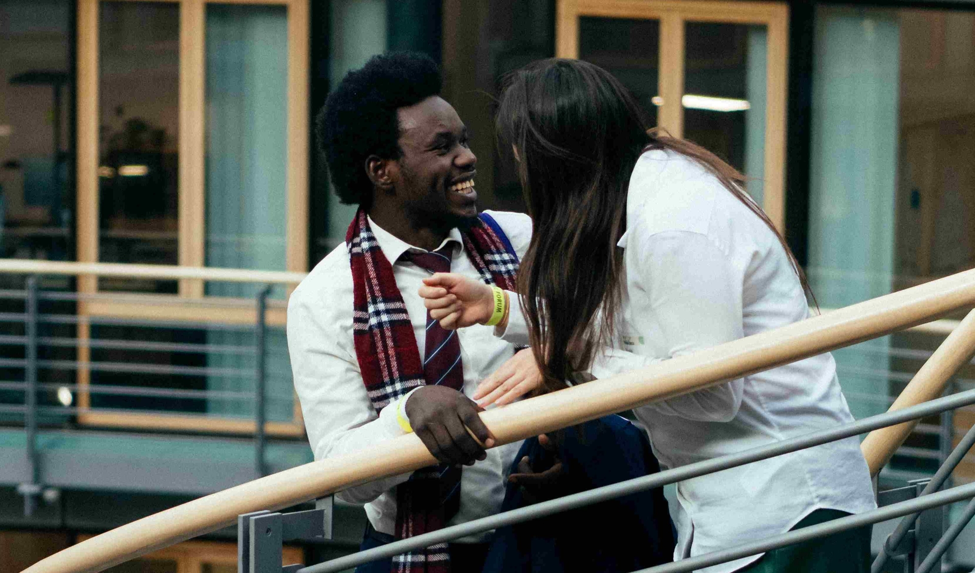 Two people are chatting and laughing on stairs.