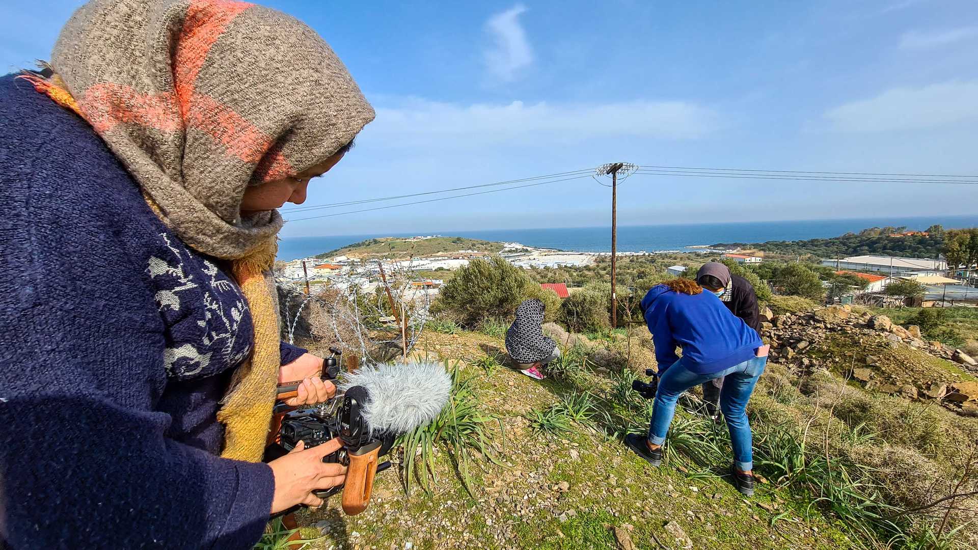Two women are outside on Lesvos and are filming in the landscape.