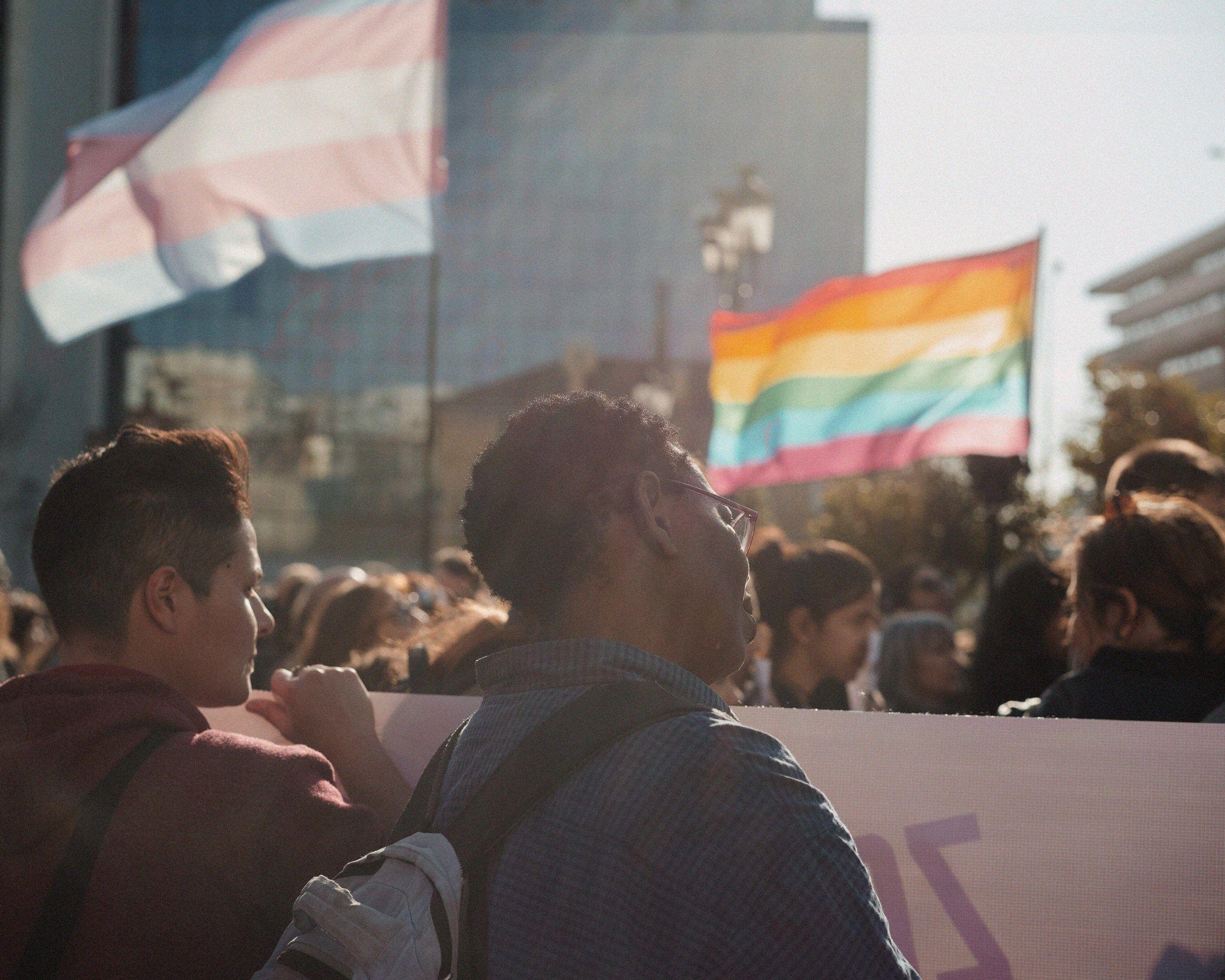 Couple of people are standing on a demonstratiion, in the background you see different flags