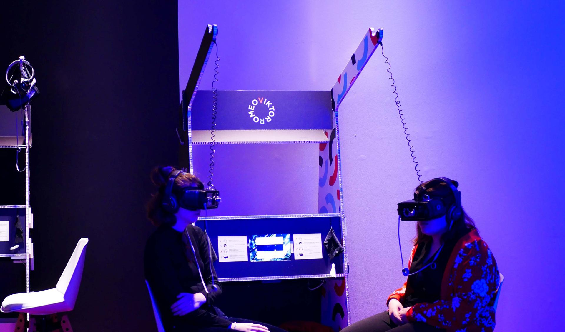 Two people sitting in a room with VR-headsets