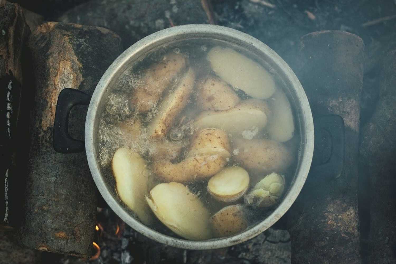 Boiling Potatoes in a pot on a wooden fireplace in Idomeni