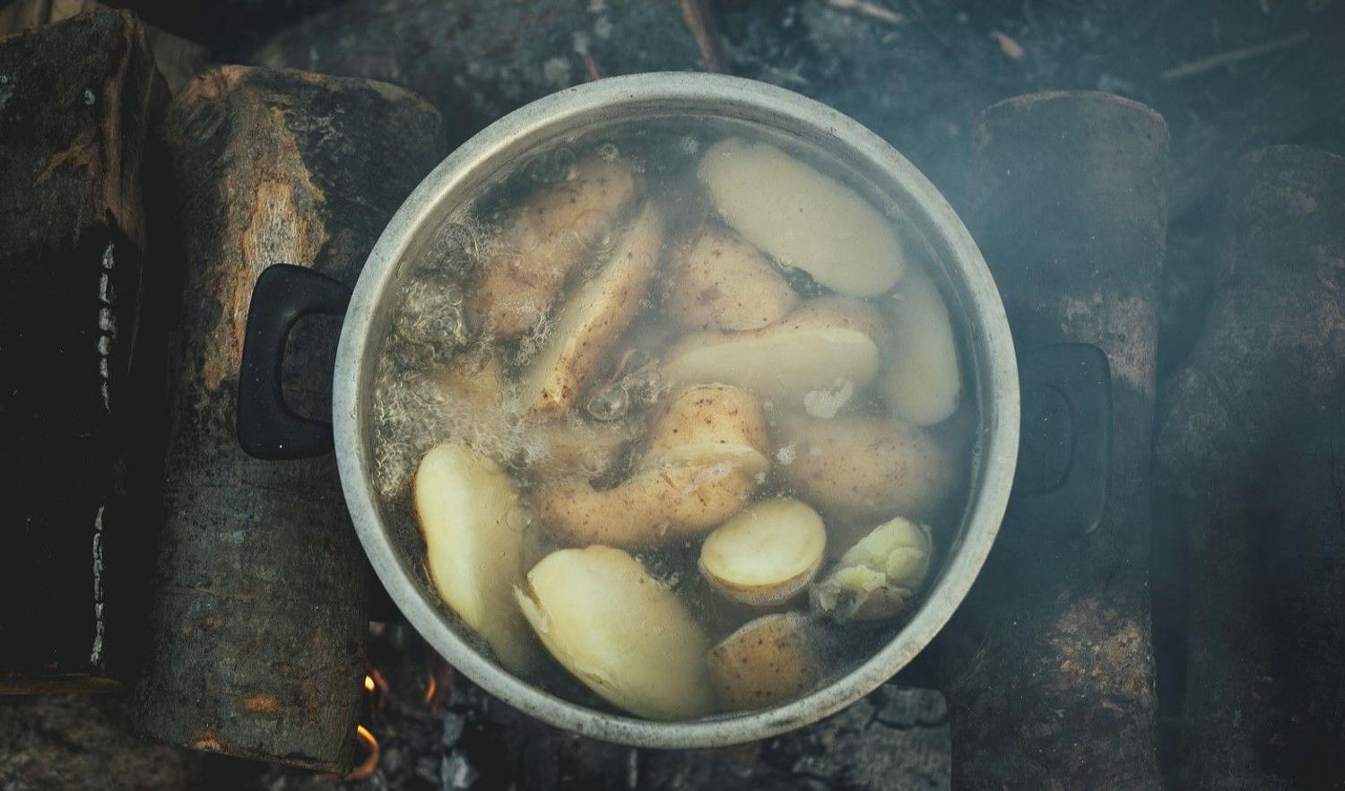 Boiling Potatoes in a pot on a wooden fireplace in Idomeni