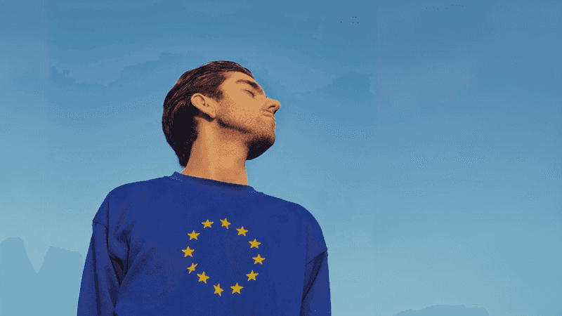 Person wearing EU pullover with their head turned to the sky