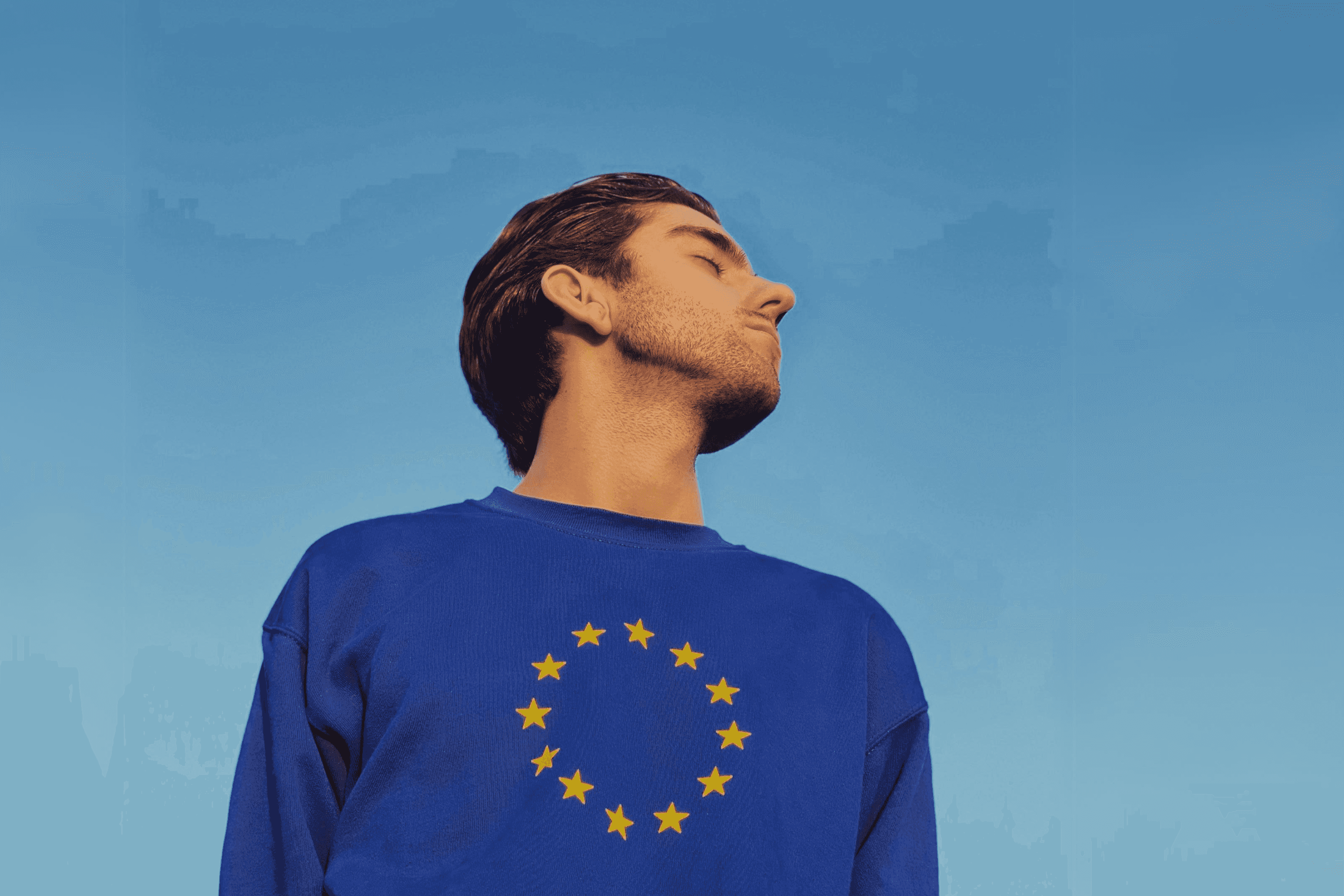 Person wearing EU pullover with their head turned to the sky