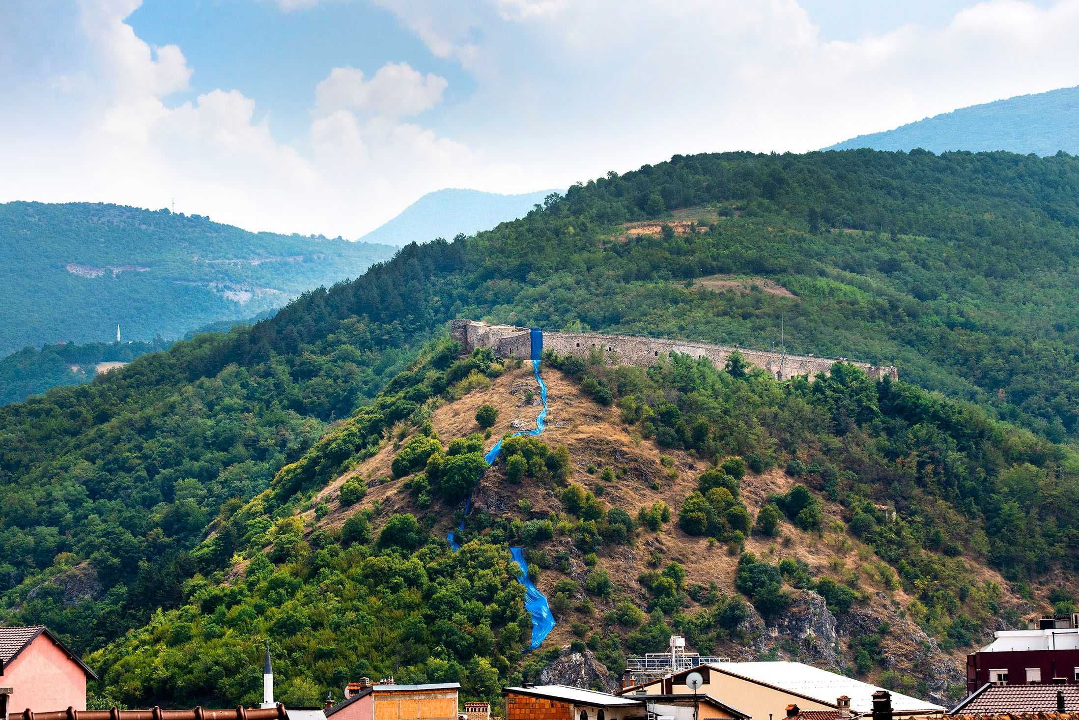 Streams of blue fabric by Hera Büyüktaşciya runs down a hill near Prizren