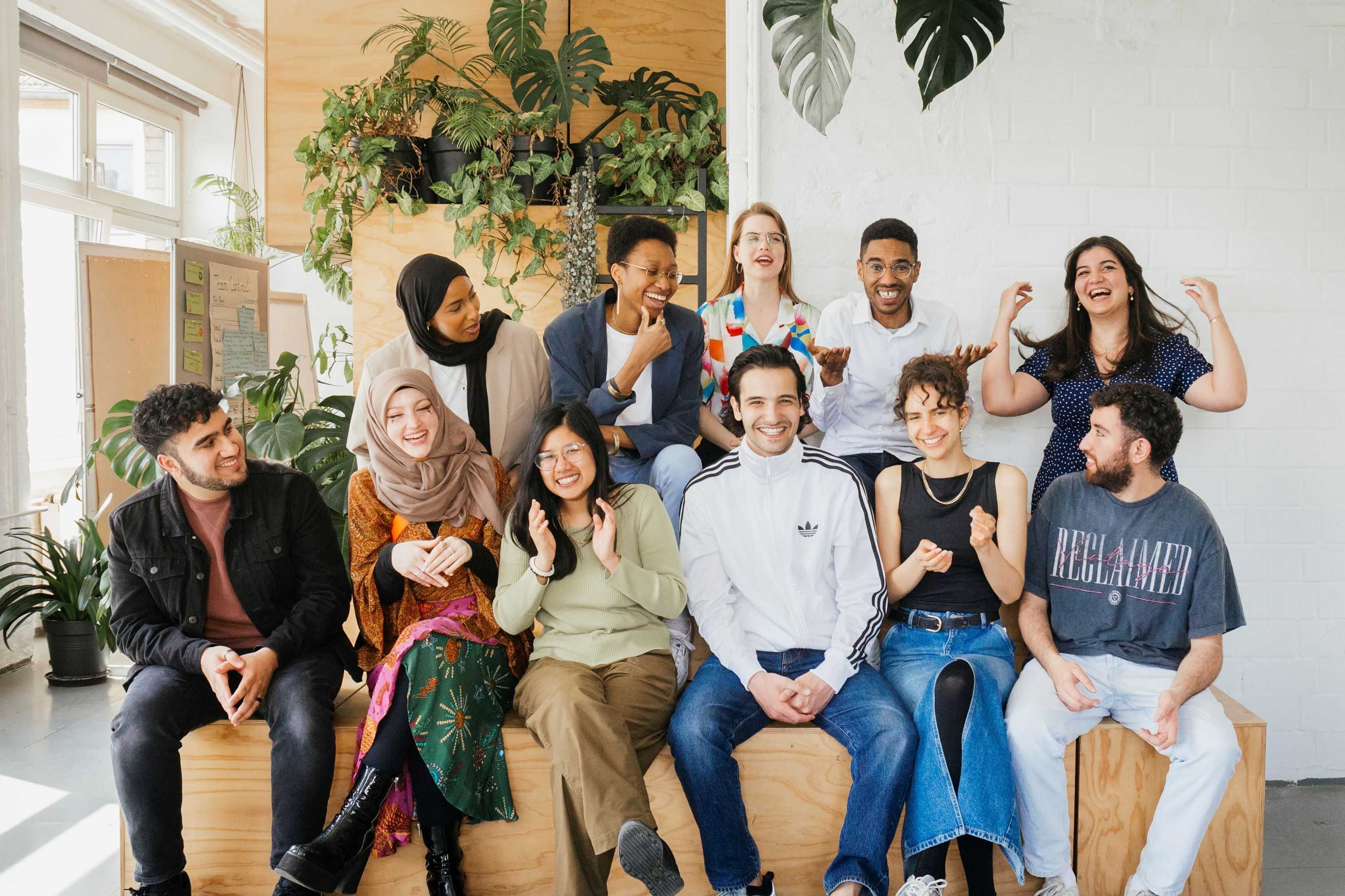 A group of people is sitting on a wooden structure.