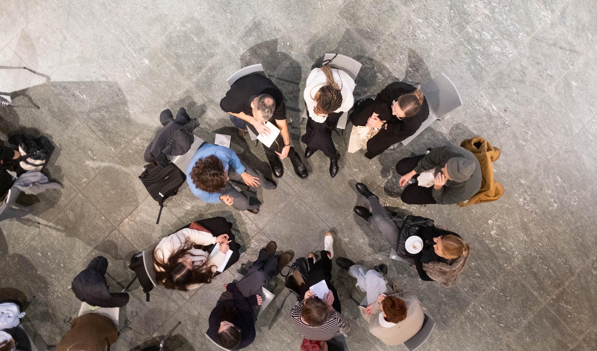 A group of people is sitting together in a circle and is talking